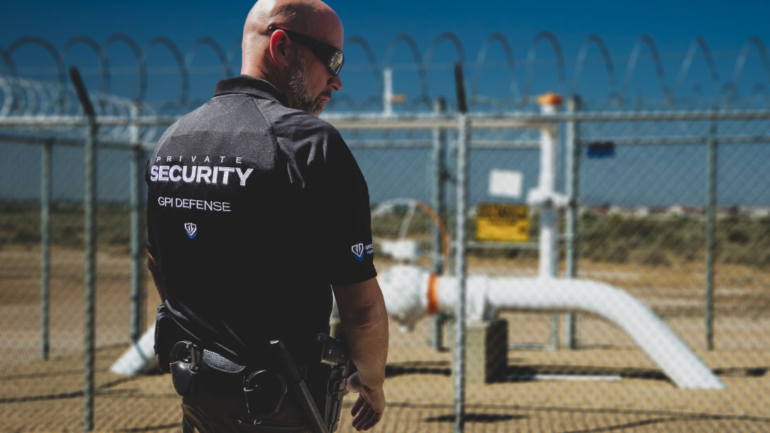 Security guard from GPI Defense patrolling an oilfield site, ensuring protection of high-value equipment and safeguarding the perimeter with surveillance.