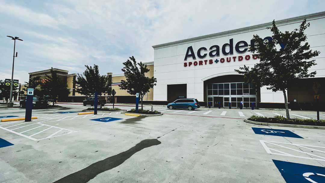 Exterior view of shopping center with Academy Sports, emphasizing retail security to prevent shrinkage and protect profits.