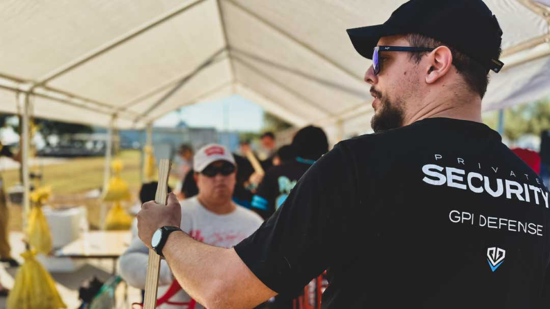 A GPI Defense private security team member assisting at a community event, representing choosing a security company that prioritizes professionalism and trust.