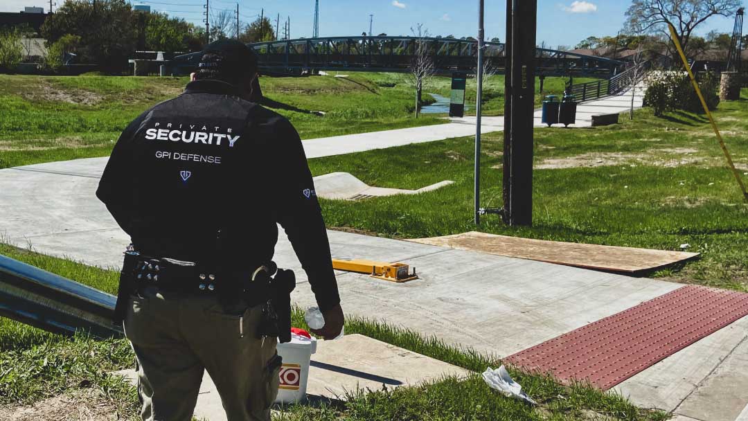 Professional security guard walking towards a checkpoint in a clean, GPI Defense branded uniform, emphasizing safety and reliability.